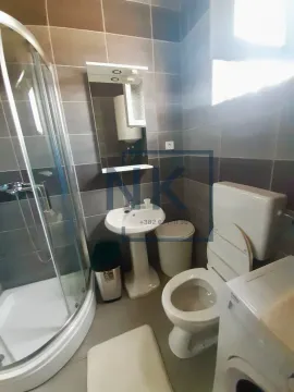 Bathroom equipped with a shower cabin, washbasin, and toilet. - image 2