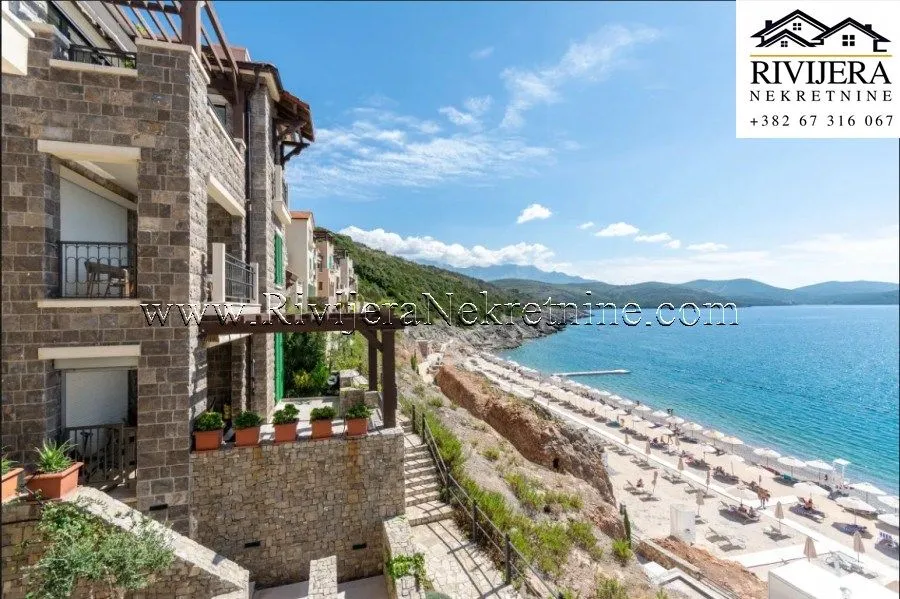 Pogled na spoljašnjost zgrade i obližnju plažu sa morem.