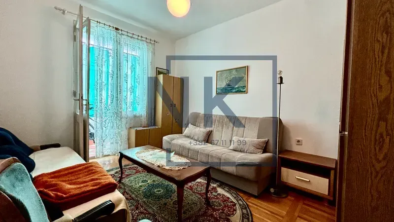 Dnevna soba sa garniturom za sjedenje, stočićem i izlazom na terasu.