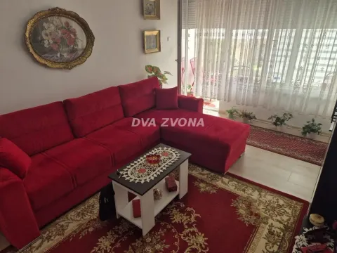 Dnevna soba sa velikom crvenom ugaonom garniturom i stočićem. - image 5