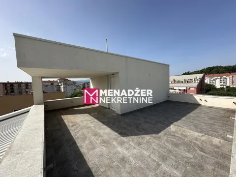 Large tiled roof terrace with a city view. - image 11