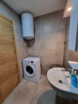 Bathroom with a washbasin, washing machine and a wall-mounted water heater. - image 18