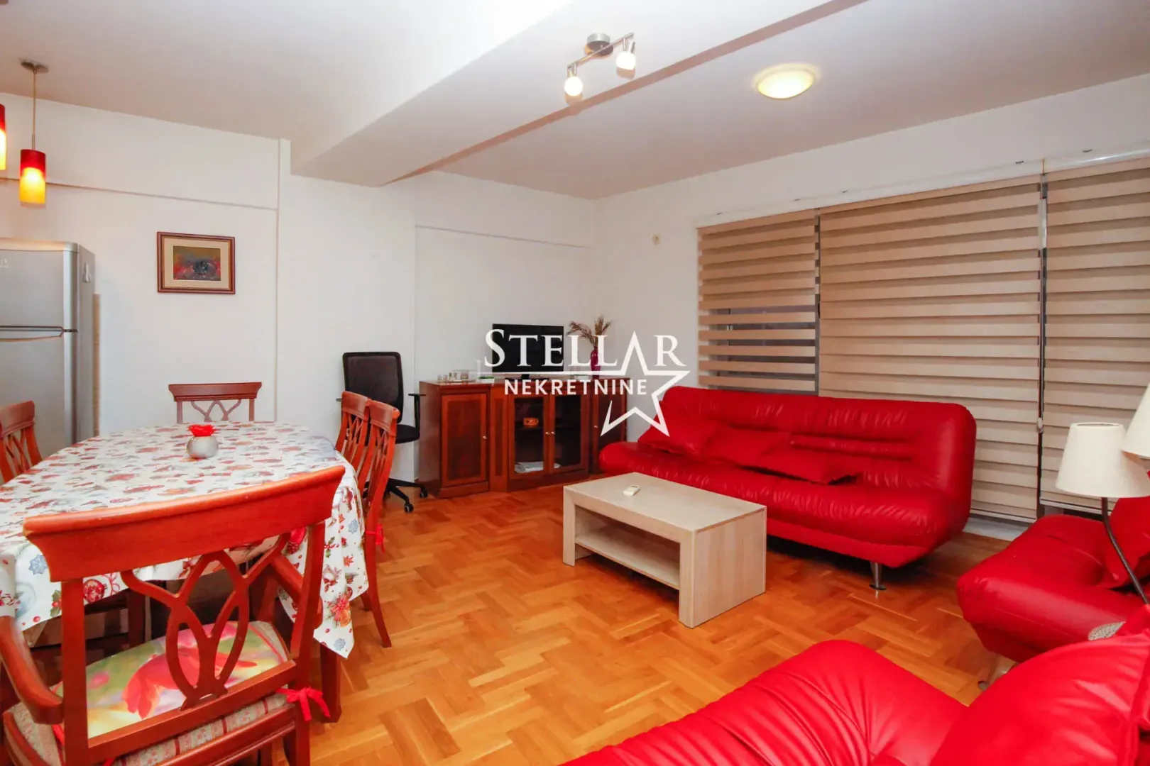Living room with red sofas and a dining area.