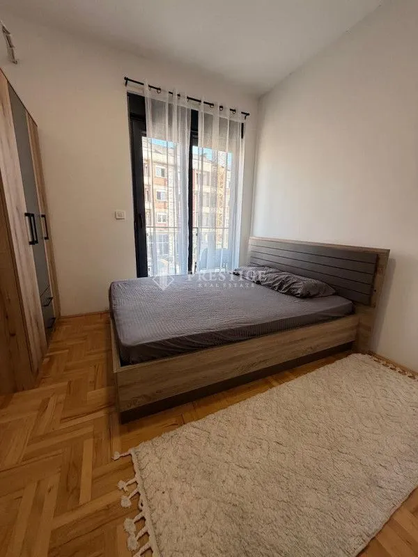 Furnished bedroom with a double bed and a wardrobe.