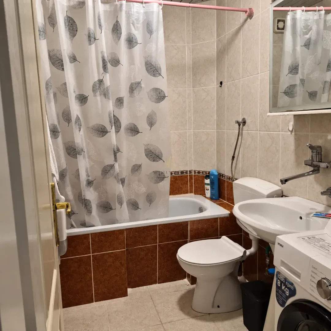 Kupatilo opremljeno kadom, umivaonikom, WC šoljom i veš mašinom.