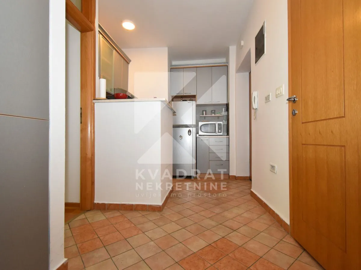 Small kitchen with tiled floor and built-in units.