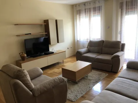 Bright living room with a sofa set and a TV stand. - image 2