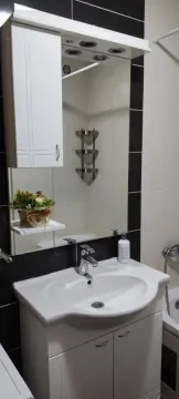 Kupatilo sa umivaonikom, ormarićem sa ogledalom i pločicama u kontrastnim bojama. - image 14