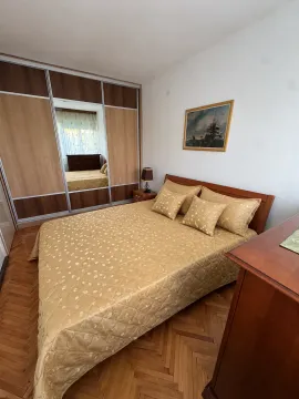 Namještena spavaća soba sa bračnim krevetom, velikim ormarom i drvenim podom. - image 3