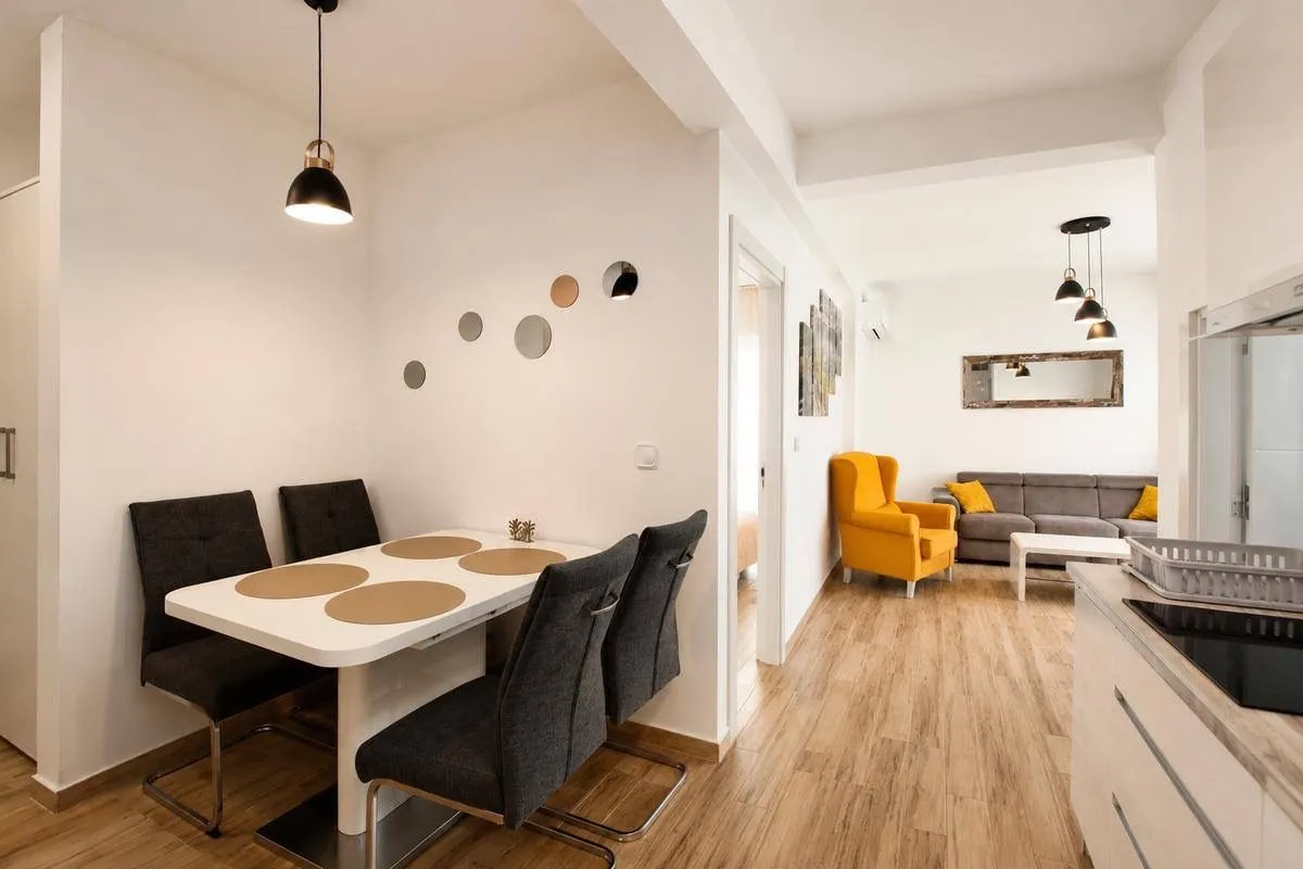 Modern interior with a dining area and living room in bright tones.
