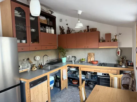 Namještena kuhinja sa drvenim elementima i trpezarijskim stolom. - image 3