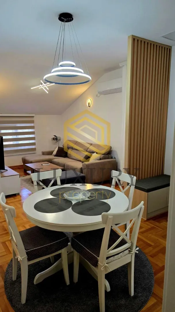 Dnevna soba sa trpezarijom i modernim osvjetljenjem.