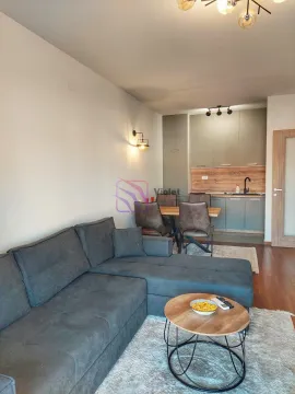 Living room with a sectional sofa, dining area, and kitchen in the background. - image 3
