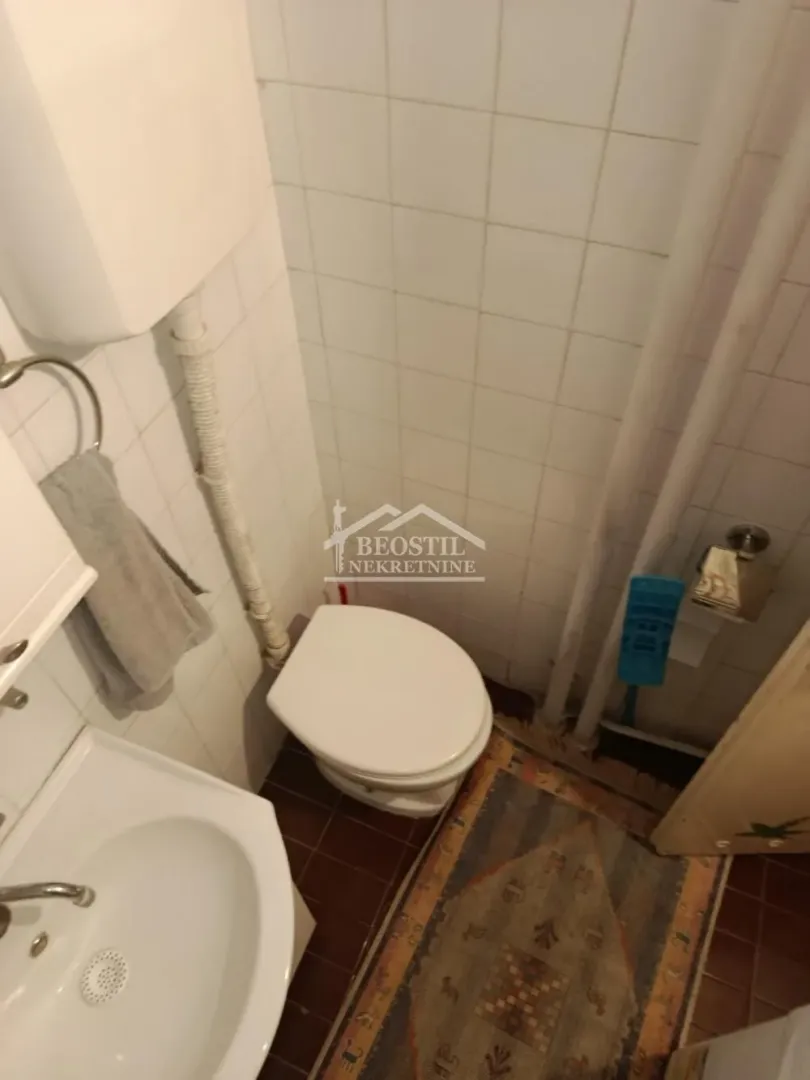 Smaller tiled bathroom with a toilet and a sink.