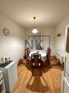Dining room with a wooden table, chairs, and laminate flooring. - image 5