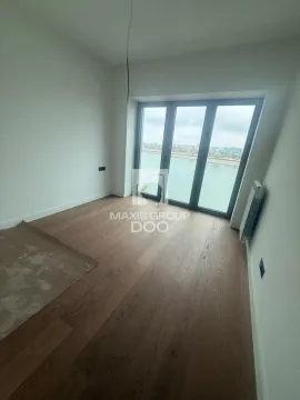 Empty room with wooden flooring and a large window overlooking the river. - image 6