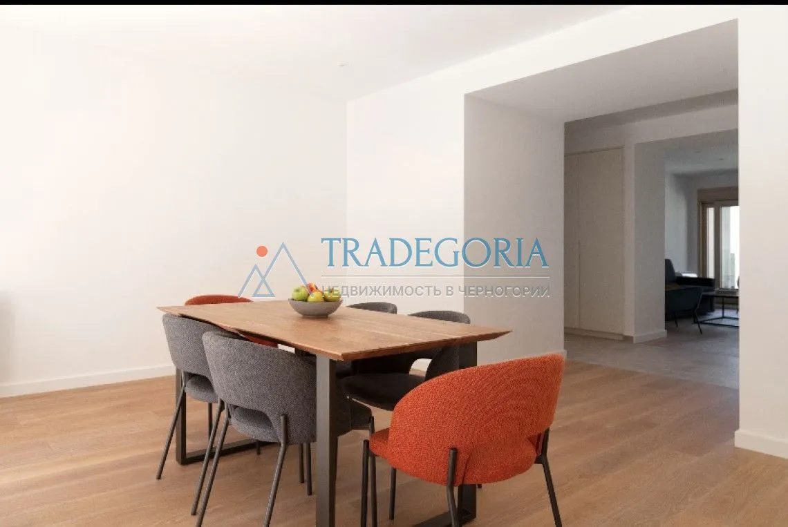 Trpezarija sa drvenim stolom i modernim stolicama u stanu.