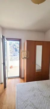 Bedroom with a bed, wooden wardrobe, and access to the terrace. - image 5