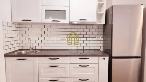 Bijela kuhinja sa radnom površinom, sudoperom i frižiderom. - image 7