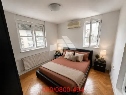 Furnished bedroom with a double bed, two windows, and parquet flooring. - image 5