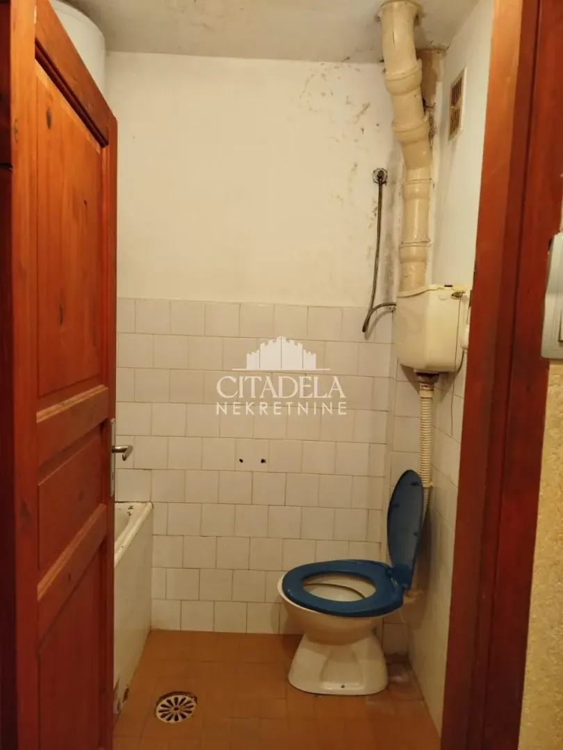 Starije opremljeno kupatilo sa kadom i toaletom.
