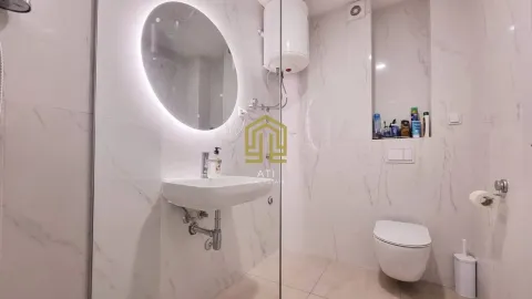 Moderno opremljeno kupatilo sa umivaonikom, ogledalom i WC šoljom. - image 9