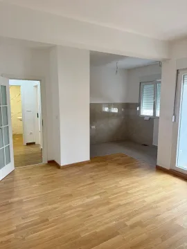 Empty bright living room with parquet flooring and a view of the kitchen and hallway. - image 8