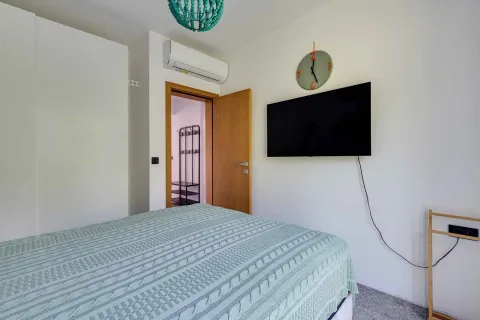 Namještena spavaća soba sa krevetom, televizorom na zidu i klima uređajem. - image 32