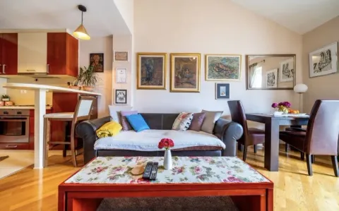 Living room with a sofa and dining area in an open-plan space. - image 2