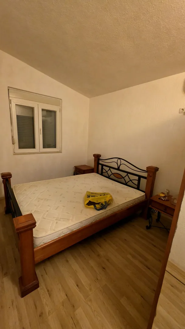 Spavaća soba sa bračnim krevetom i prozorom.