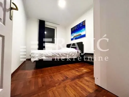 Smaller bedroom with a double bed and parquet flooring.