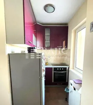 Small kitchen with purple cabinets and built-in appliances. - image 7