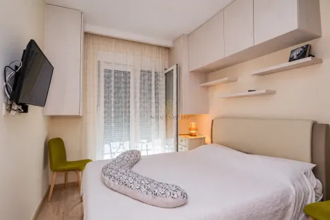Furnished bedroom with a double bed, built-in cabinetry, and a TV. - image 9