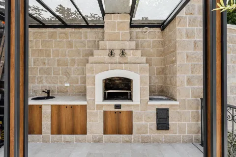 Covered outdoor area with a built-in barbecue, sink, and countertop. - image 17