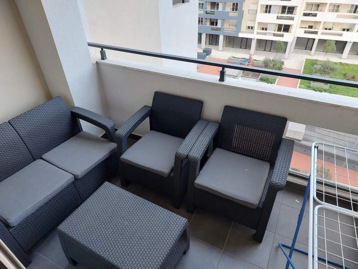 Namješten balkon sa garniturom za sjedenje i pogledom na naselje.