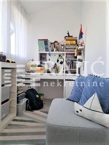 Children's bedroom with a bed, desk, and bookshelves.