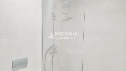 Moderna tuš kabina sa staklenom pregradom u svetlom kupatilu. - image 6