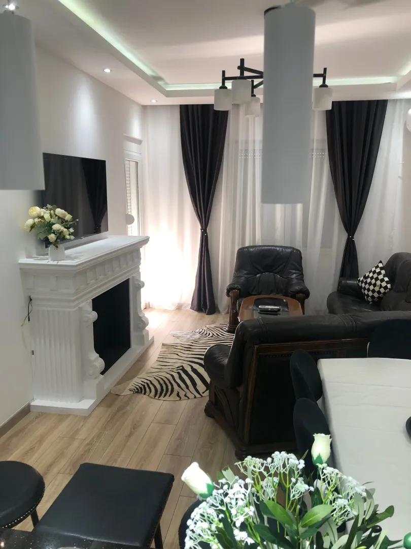 Living room with a fireplace, sofa set, and dining table.