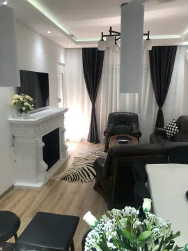 Living room with a fireplace, sofa set, and dining table. - image 14