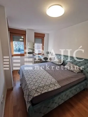 Furnished bedroom with a double bed and windows.