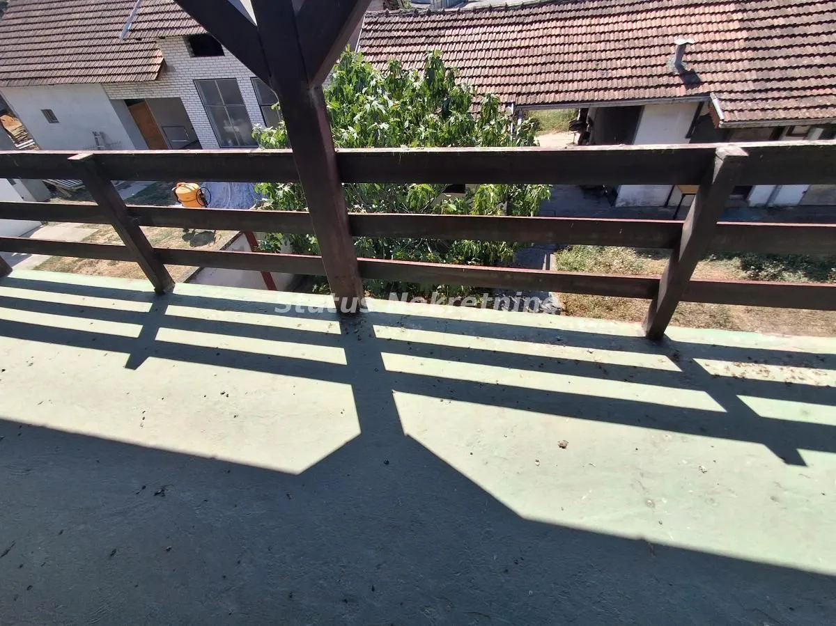 Pogled sa balkona na dvorište i okolne kuće.