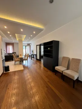 Spacious and bright open-plan living room with a dining area and wooden flooring. - image 5
