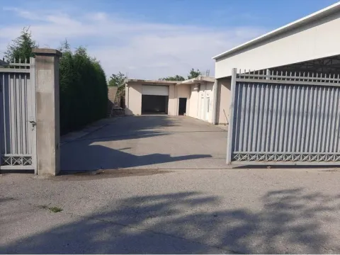 Driveway and entrance to the yard of a commercial building with a metal gate. - image 11