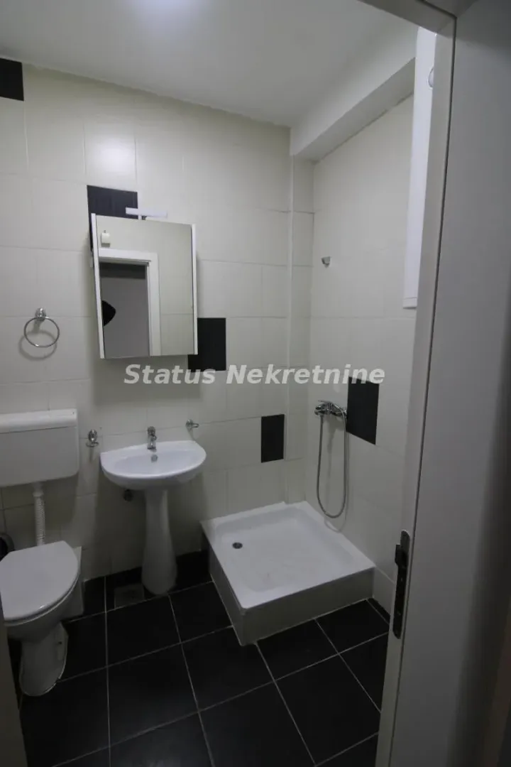 Manje kupatilo sa tuš kabinom, umivaonikom i wc šoljom.