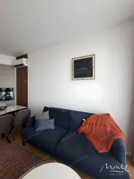 Dnevna soba sa udobnom plavom sofom i zidnim satom. - image 6