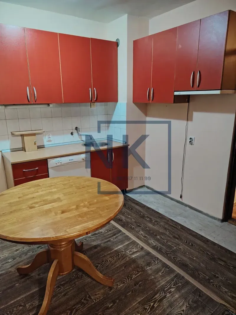 Kitchen with red cabinets and a wooden dining table.