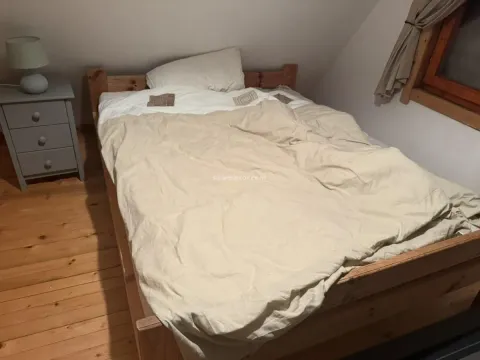 Bedroom with a wooden bed and a bedside table. - image 7