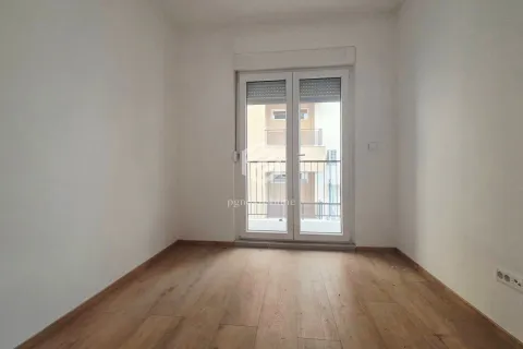 Prazna neopremljena soba sa drvenim podom i balkonskim vratima. - image 3