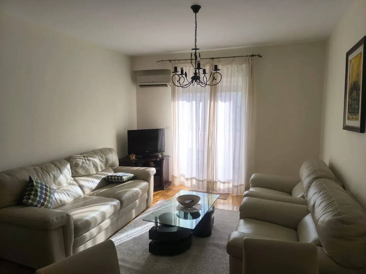 Living room with sofa set, coffee table, and TV.