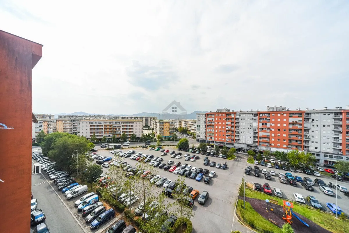 Pogled sa terase na okolne stambene zgrade i parking.